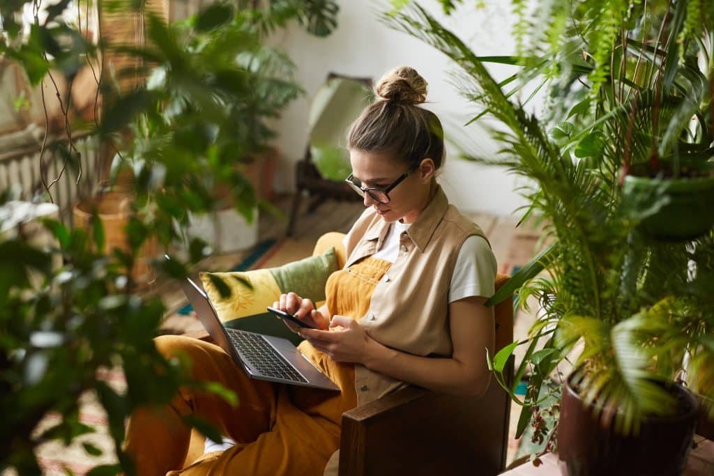 A woman sitting in a chair and using a laptop.